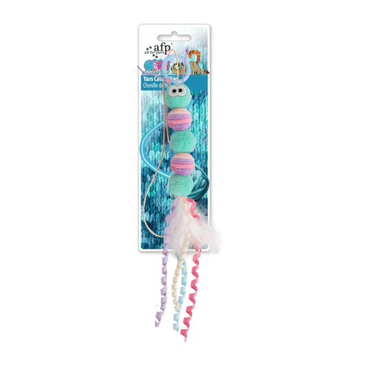 Yarn caterpillar cat toy: green plush with pink and cream yarn pom details