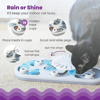 Gray cat using a blue and white cloud-shaped treat puzzle with pegs and wheel
