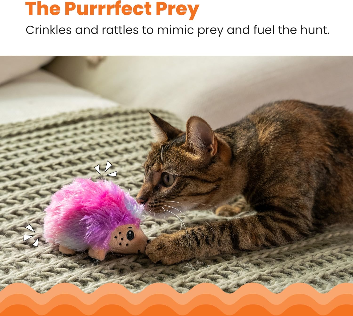 Cat playing with a pink and purple toy on a textured surface.