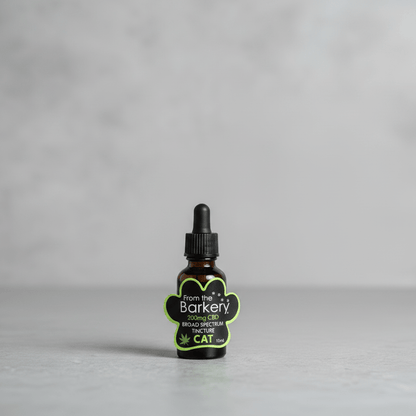 Amber tincture dropper bottle with black cap and green From the Barkery cat label