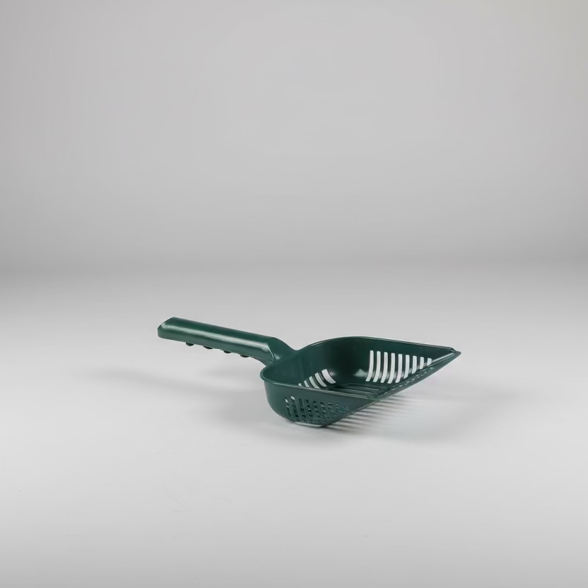 green plastic cat litter scoop on a white background