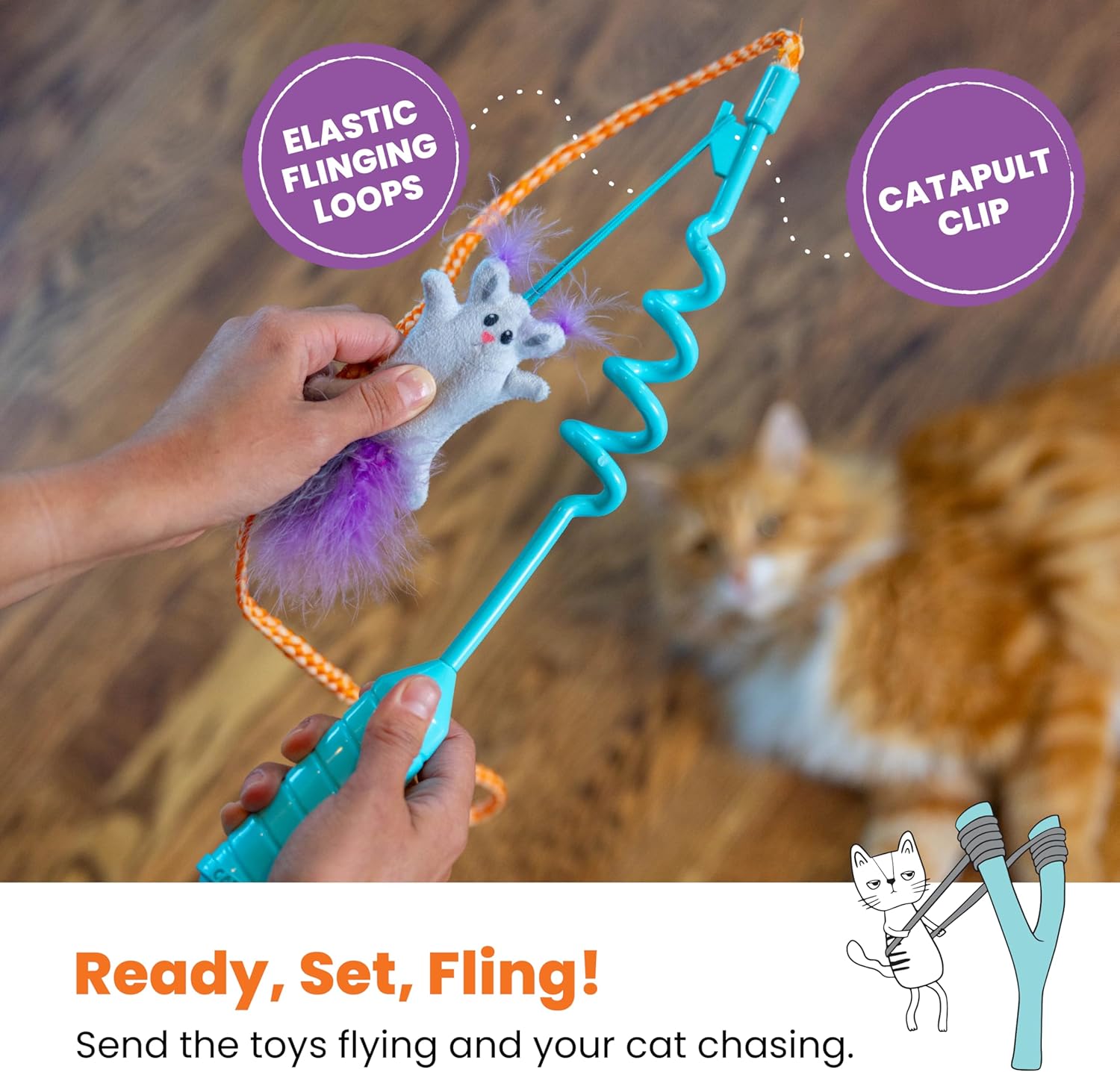 Cat toy with elastic flinging loops and catapult clip, held by a person with a cat in the background.