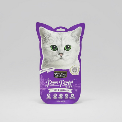 Purple package of Kit Cat Pur Péree Plus+ tuna and collagen cat food on a wooden surface.