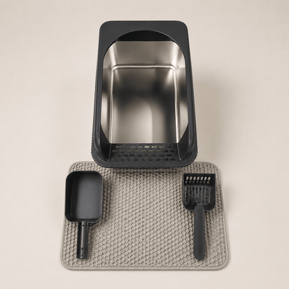 Stainless steel and black plastic Cat litter box set with scoop and mat on a beige background