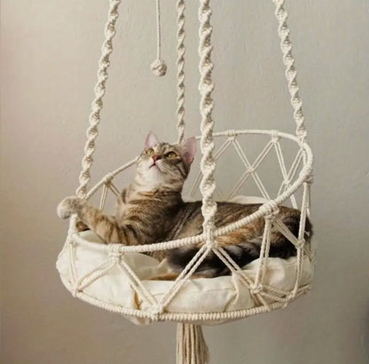 Cotton macramé hanging cat hammock with a tabby cat resting inside