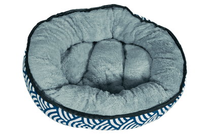 Reversible plush kitten bed with light gray cushioned interior and blue wave sides