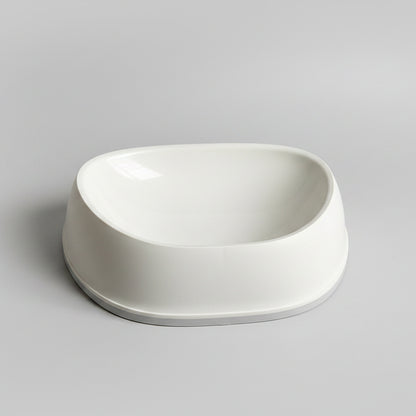 White SensiBowl pet bowl  on a white surface, with a bag of cereal in the background.